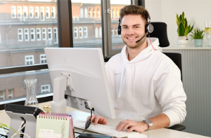auszubildender sitzt am büroarbeitsplatz.