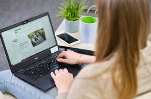 Auszubildende sucht nach Stellenanzeigen auf dem Laptop.