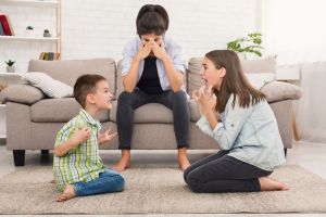 Verzweifelte Mutter mit streitenden Kindern