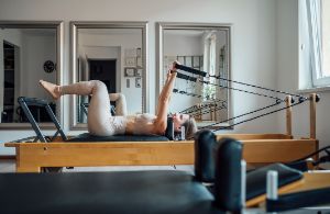 Eine Frau übt Reformer Pilates aus.
